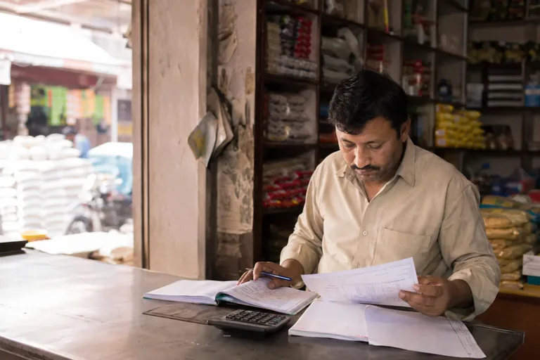 An Indian shop owner reviewing business finances